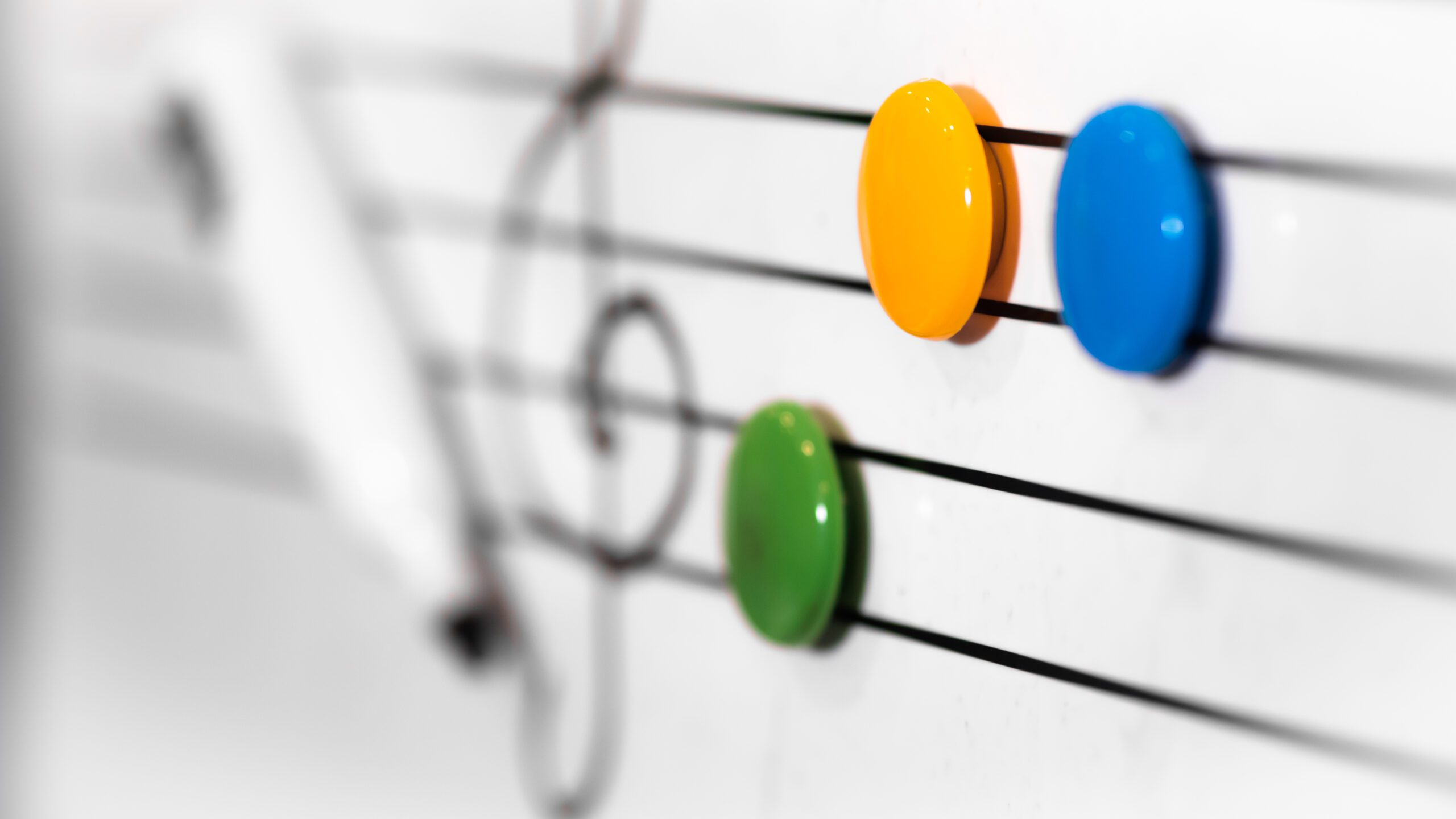 A whiteboard with a music staff and magnets representing musical notes