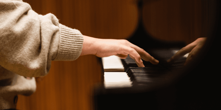 A photo of a pianist playing on a grand piano.