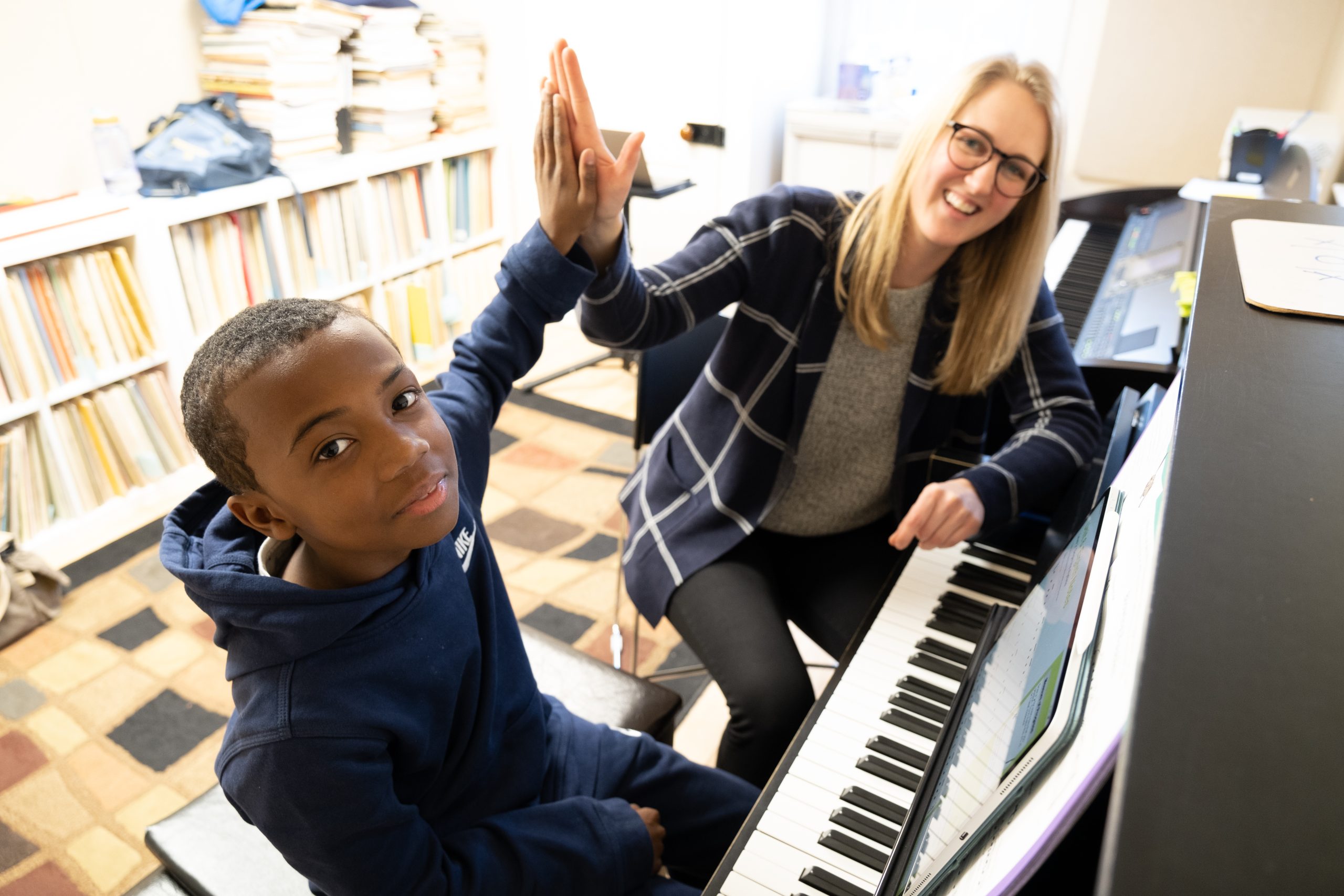 A teacher from the New School for Music Study with a student at the piano.