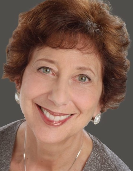 Phyllis Lehrer professional headshot, smiling in a gray top against a neutral background.